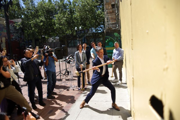 Mayor Matt Mahan uses a sledge hammer to knock a panel out of a wall at the Bank of Italy building on Monday, April 6, 2026, in San Jose, Calif. Construction will transform former office space in the Bank of Italy building into a 109 new residential units. (Aric Crabb/Bay Area News Group)