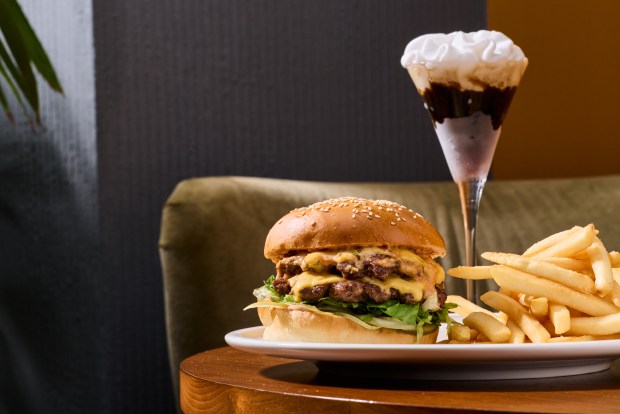 The burger at Causwells in Menlo Park will be the same as its San Francisco counterpart, featuring house recipe ground beef, American cheese, lacto-fermented pickles, onion, lettuce and on a sesame seed bun. It's shown here served with an espresso martini and fries. (Courtesy Hardy Wilson)