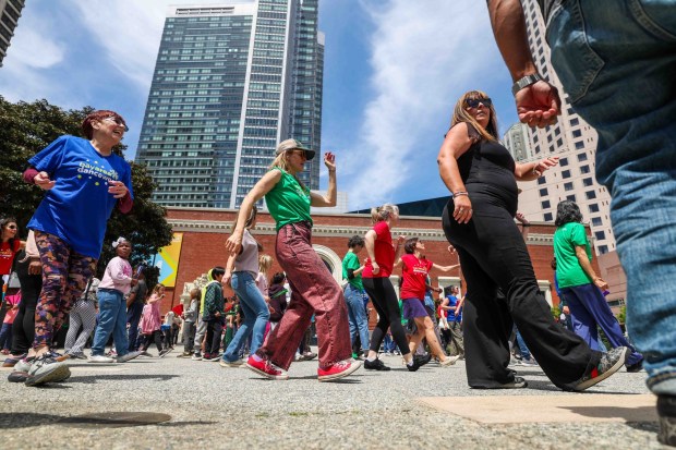 Kids and adults take part in a dance led by One Dance instructors during the Bay Area Dance Week kickoff event at Jesse Square in San Francisco, Friday, April 24, 2026. Bay Area Dance Week is a 10-day celebration of various dance styles held throughout the Bay Area. The One Dance performance included a Soul Line Dance class led by Oakland's Chocolate Platinum. (Ray Chavez/Bay Area News Group)