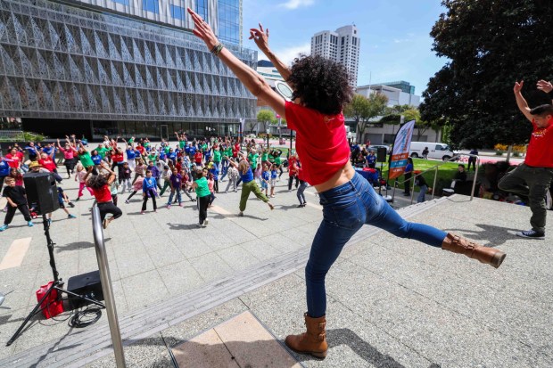 One Dance instructors Amy Rose, left, and artistic director Dudley Flores, right, lead a high-energy dance during the Bay Area Dance Week kickoff eventin San Francisco, Friday, April 24, 2026. Bay Area Dance Week is a 10-day celebration of various dance styles held throughout the Bay Area. The One Dance performance included a Soul Line Dance class led by Oakland's Chocolate Platinum. (Ray Chavez/Bay Area News Group)