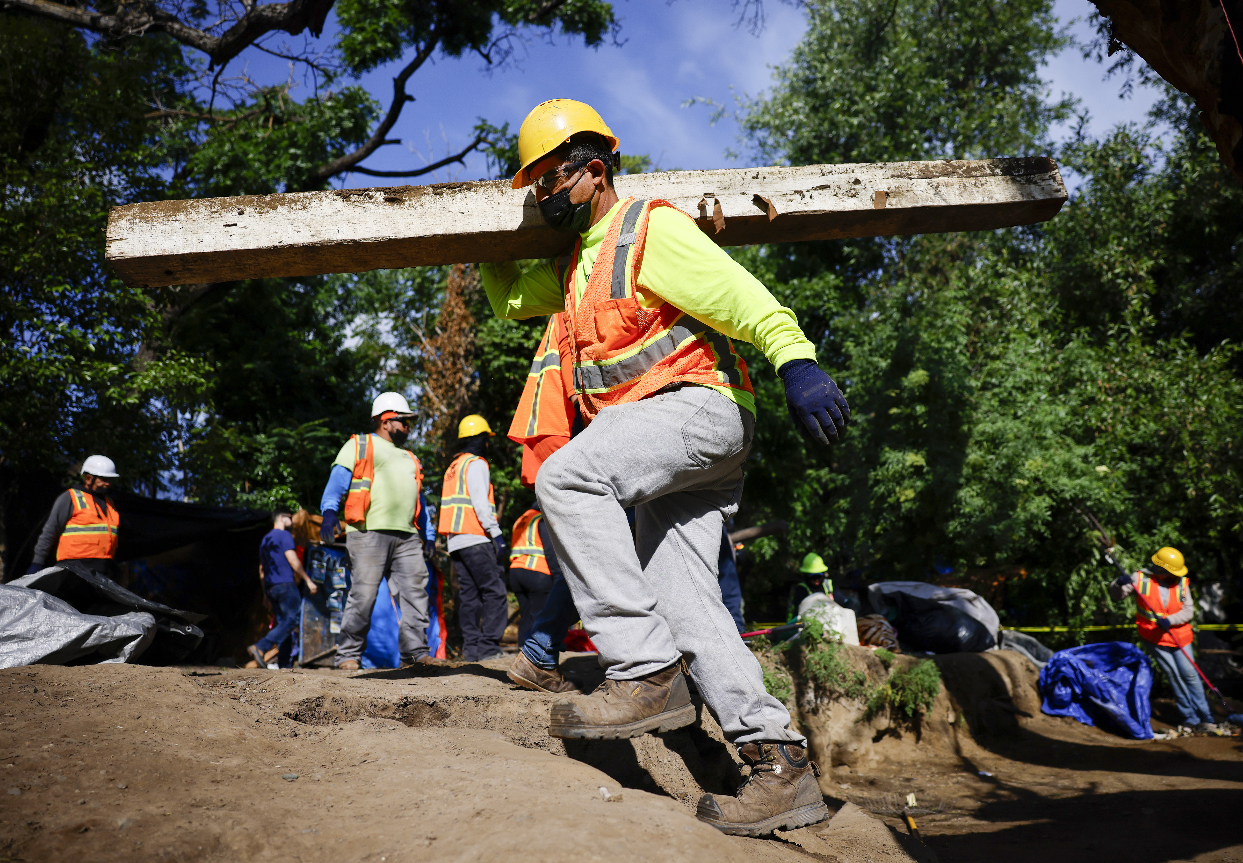 Workers from Tucker Construction clear campsites in the homeless encampment...