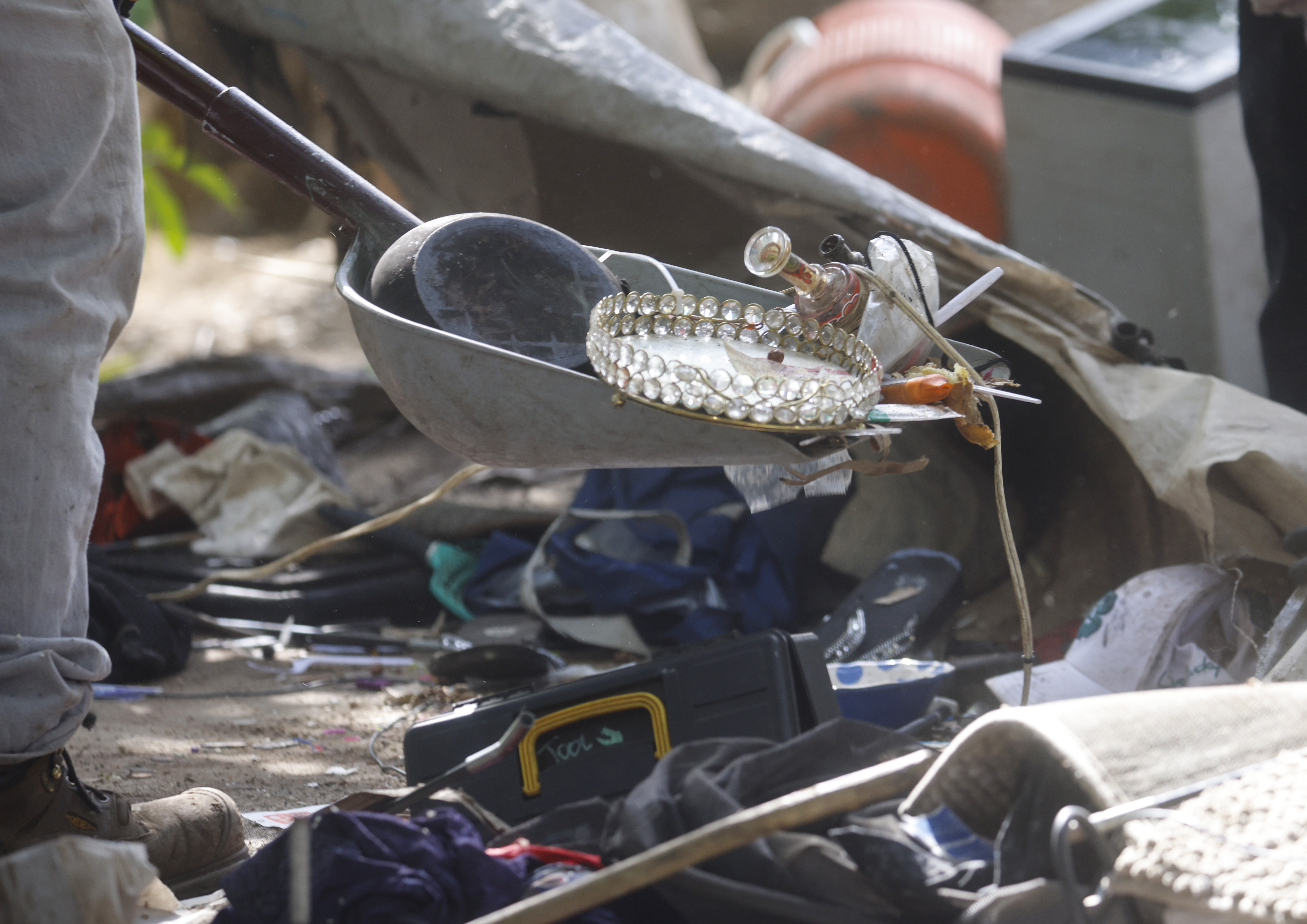 Workers from Tucker Construction clear campsites in the homeless encampment...