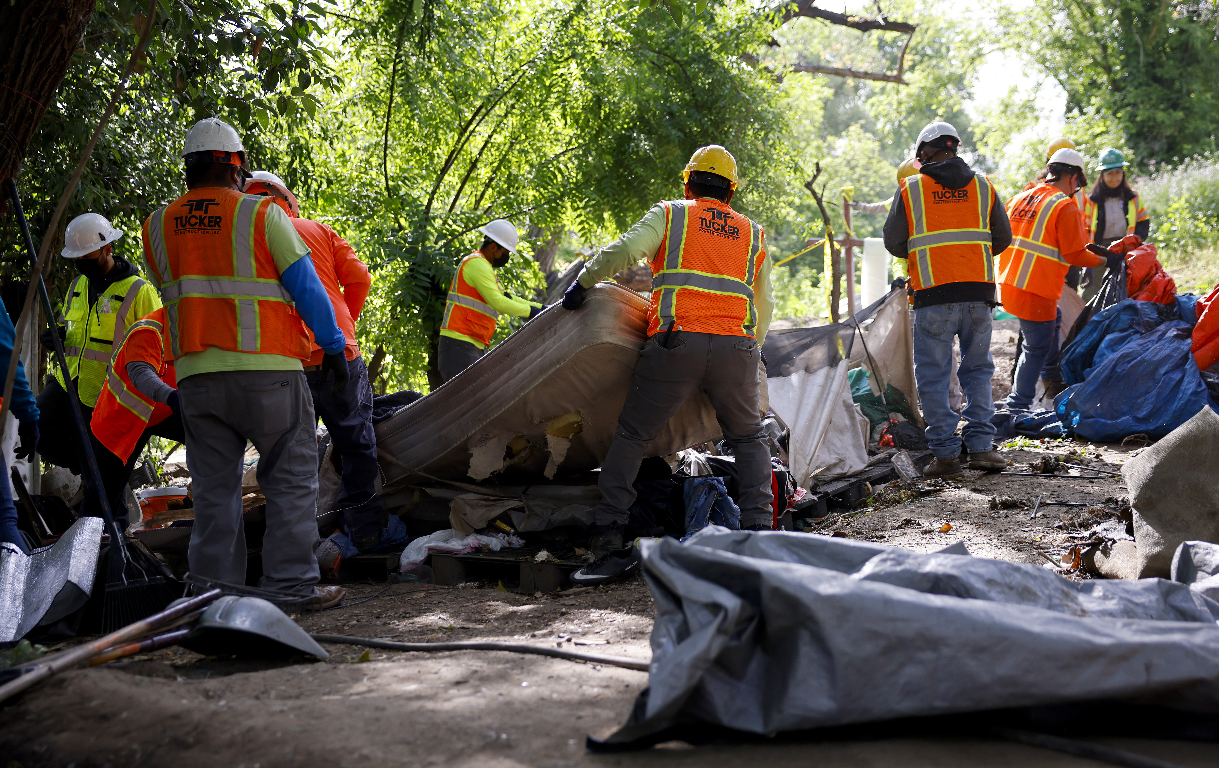 Workers from Tucker Construction clear campsites in the homeless encampment...