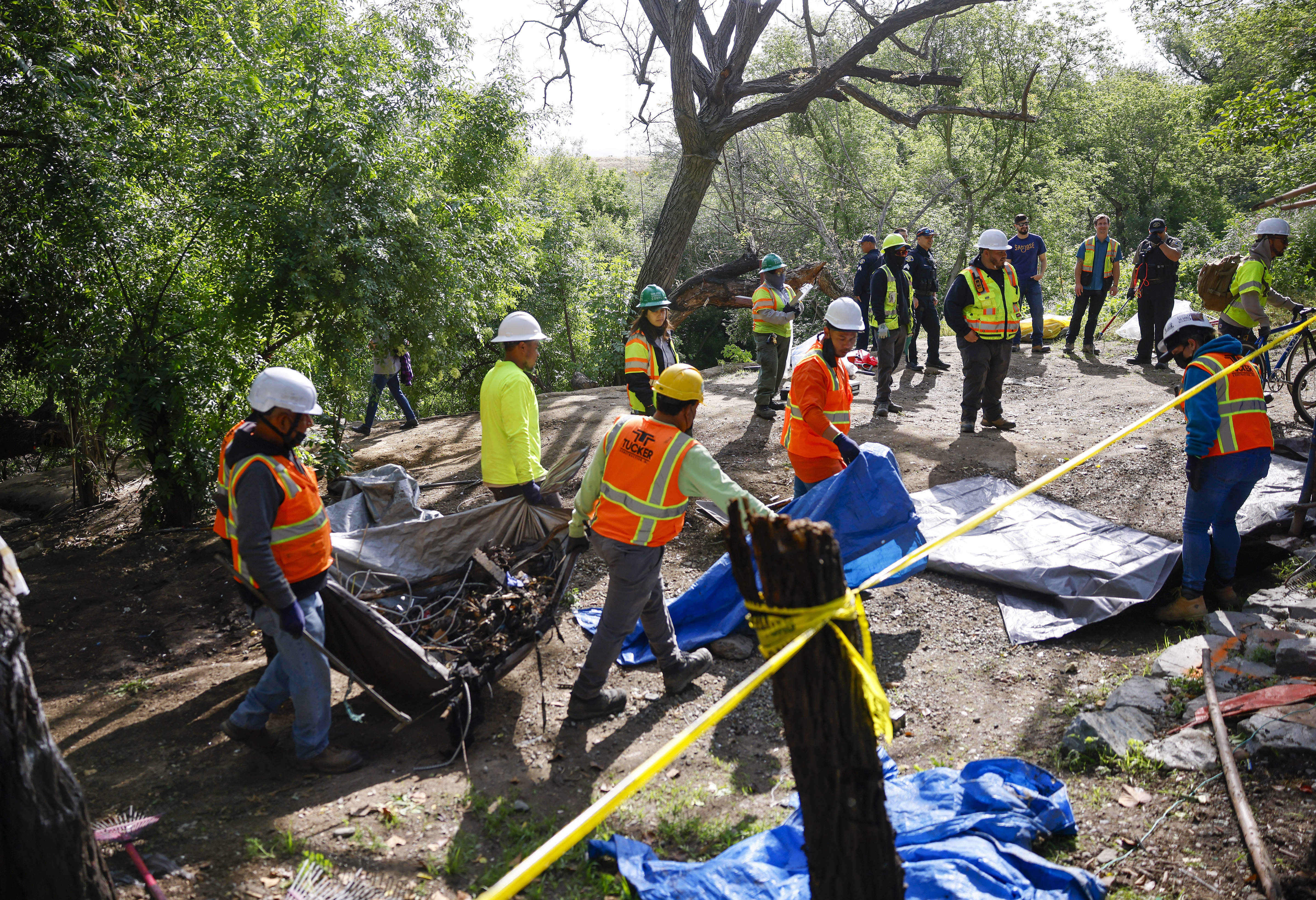 Workers from Tucker Construction clear campsites in the homeless encampment...