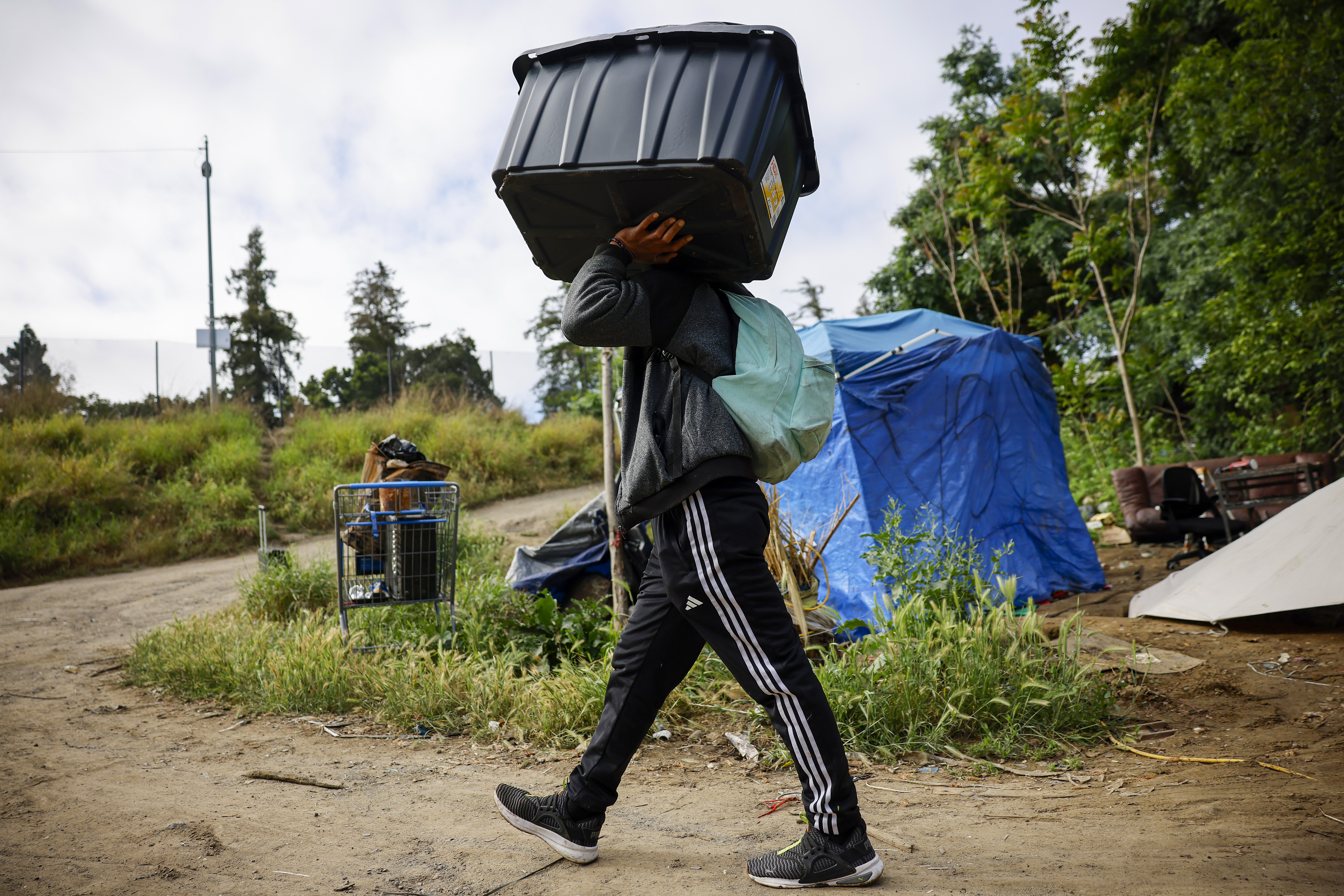 A man carries a bin of items out of the...