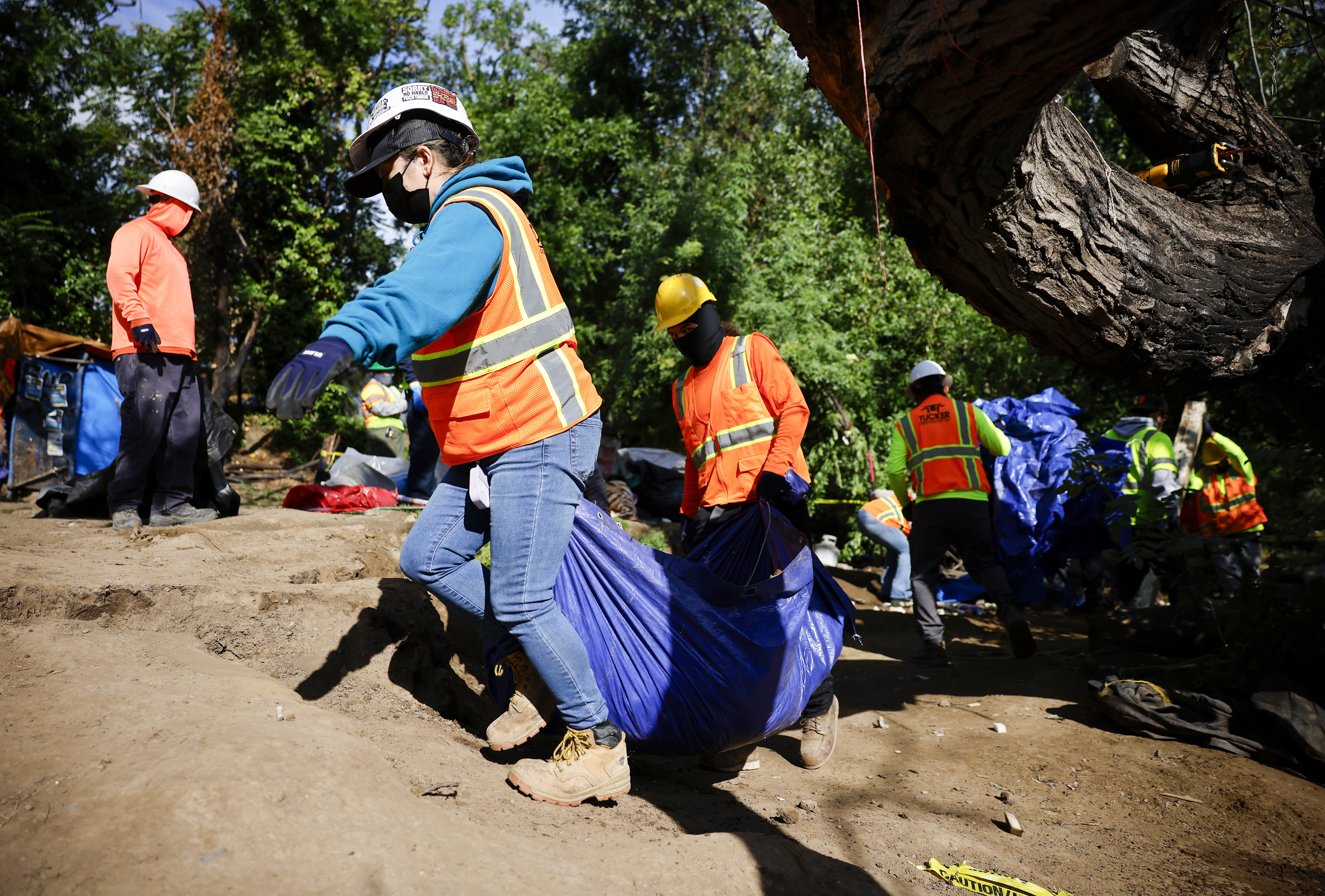 Workers from Tucker Construction clear campsites in the homeless encampment...