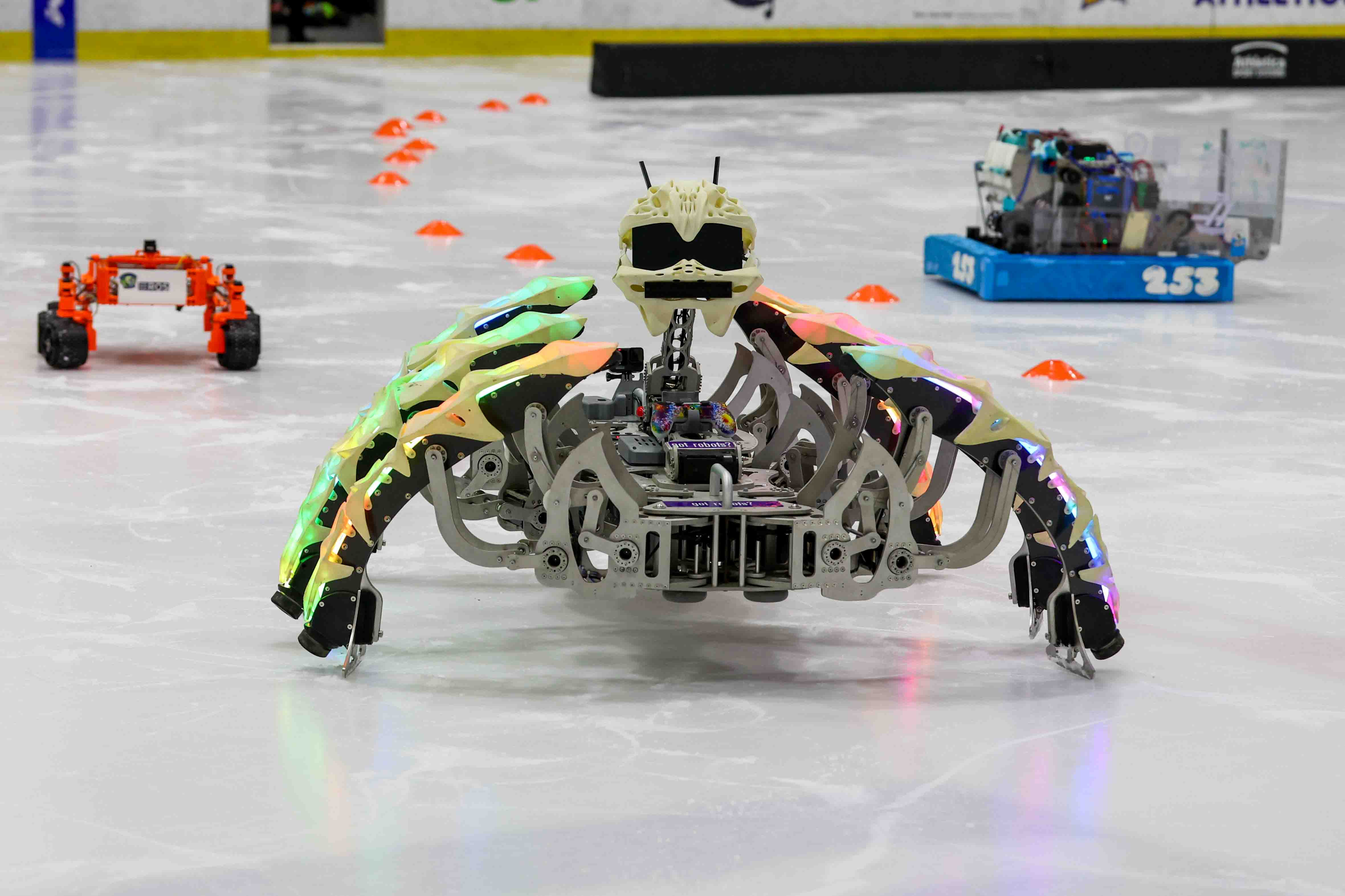 Marauder, center, a hexapod robot designed by Nick Donaldson, moves...