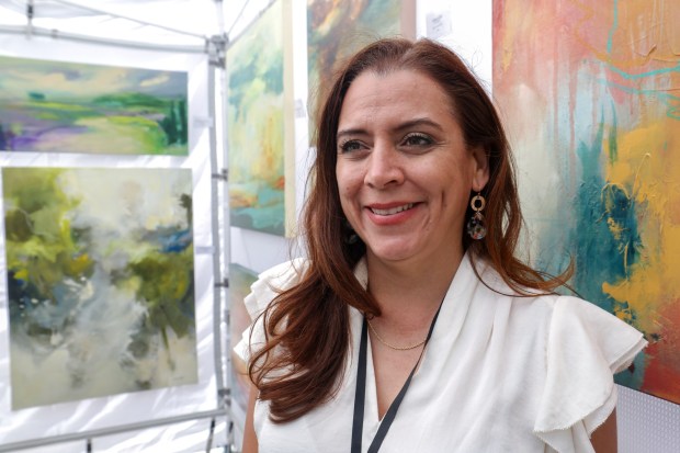l Artist Karla Preciado of Chula Vista next to her paintings during the Mission Fed Art Walk in Little Italy in San Diego on Sunday, April 26, 2026. (Hayne Palmour IV / For The San Diego Union-Tribune)