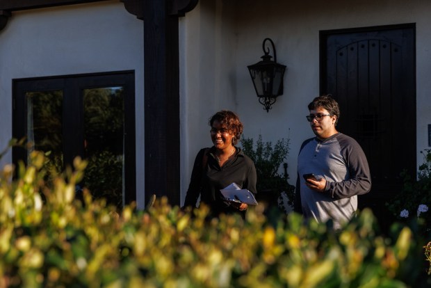 Congressional candidate Sparky Mitra and volunteer Frank Granda walk away from a home in Pacific Beach on Wednesday, March 11, 2026. Mitra is running against Rep. Scott Peters to represent the 50th Congressional District. (Kristian Carreon / The San Diego Union-Tribune)