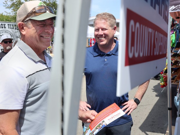 Fallbrook, CA_4_19_26_Superrvisor candidate Kyle Krahel, right a Democrat, greeted prospective voters like Jacque Corpora, left, of Vista, at the Fallbrook Avocado Festival. Photo by John Gastaldo for the Union-Tribune