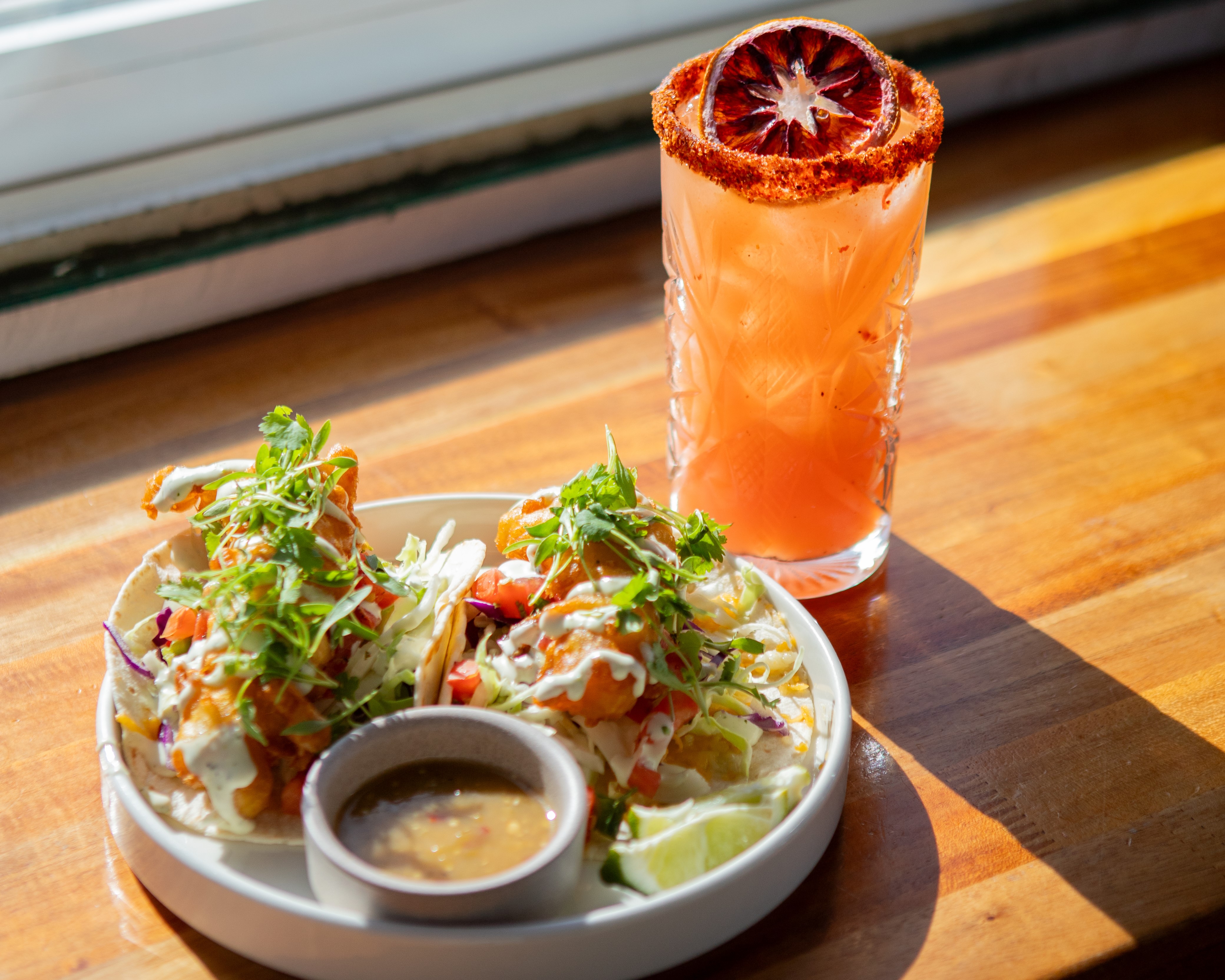 Wonderland Ocean Pub’s fire dancer cocktail and fish tacos, both...