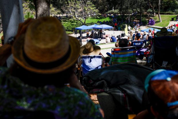Patrons watch as Troy Sandow performs during the Spring Harp Fest, celebrating the unique sounds of the harmonica, at Harry Griffen Park on Saturday, April 4, 2026 in La Mesa, California. (Meg McLaughlin / The San Diego Union-Tribune)