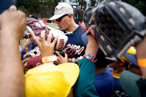 Manny Machado of the San Diego Padres is rushed by young players for autographs during the team's kids clinic at Liga Infantil de Beisbol Olmeca A.C on Friday, April 24, 2026 in Mexico City, . (Meg McLaughlin / The San Diego Union-Tribune)