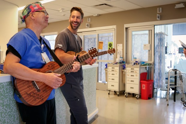 Nurse Rod Salaysay plays the Ukulele with colleague Nurse Justin Weiner at UCSD Jacobs Medical Center in La Jolla on Wednesday, April 22, 2026. Salaysay has been singing to his patients for over Two decades and plans to retire later this year. (Sandy Huffaker / For The San Diego Union-Tribune)