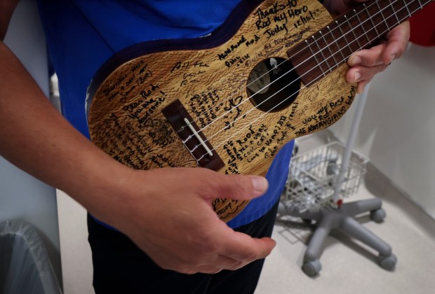 Nurse Rod Salaysay holds his Ukulele, which was signed by various patients over the years, at UCSD Jacobs Medical Center in La Jolla on Wednesday, April 22, 2026. Salaysay has been singing to his patients for over Two decades and plans to retire later this year. (Sandy Huffaker / For The San Diego Union-Tribune)