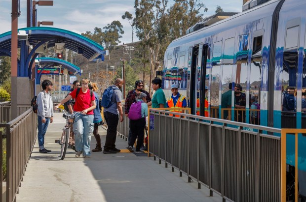 Passengers get on and off a Sprinter train at the Palomar College Station. (Charlie Neuman / For The San Diego Union-Tribune)