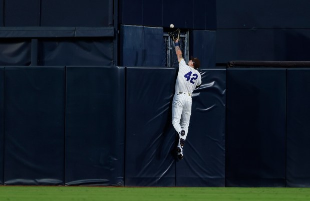 Jackson Merrill of the San Diego Padres catches the ball over the top of the wall on a fly ball hit by Julio Rodríguez of the Seattle Mariners in the third inning at Petco Park on April 15, 2026 in San Diego, CA. (K.C. Alfred / The San Diego Union-Tribune)