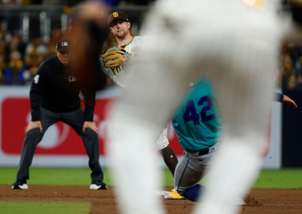 Jake Cronenworth of the San Diego Padres turns a double play against Julio Rodríguez of the Seattle Mariners at Petco Park on April 15, 2026 in San Diego, CA. (K.C. Alfred / The San Diego Union-Tribune)