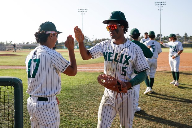 Helix's Elijah Martinez #17 and Angel Watkins #5 high five during their game against El Capitan at Helix High School on Friday, April 17, 2026 in San Diego, California. (Meg McLaughlin / The San Diego Union-Tribune)