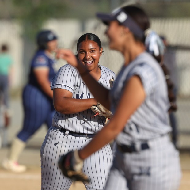 Madison's Aniyah Shelby smiles as she celebrates with teammates as they get one out away to a 6-1 win over Morse at Morse High School in San Diego on Thursday, April 16, 2026. (Hayne Palmour IV / For The San Diego Union-Tribune)