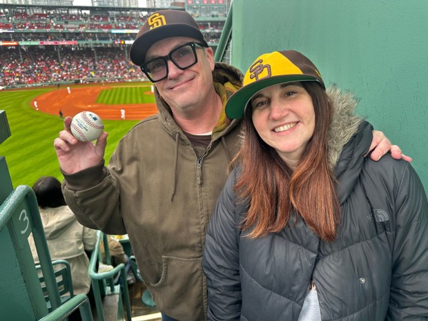Reid Bolton, left, caught Padres third baseman Manny Machado's first home run of the season while seated atop the Green Monster at Fenway Park on April 5, 2026. Bolton, who grew up in Del Mar and now lives in Buffalo, attended the game with wife Nicole. (Jeff Sanders / San Diego Union-Tribune)