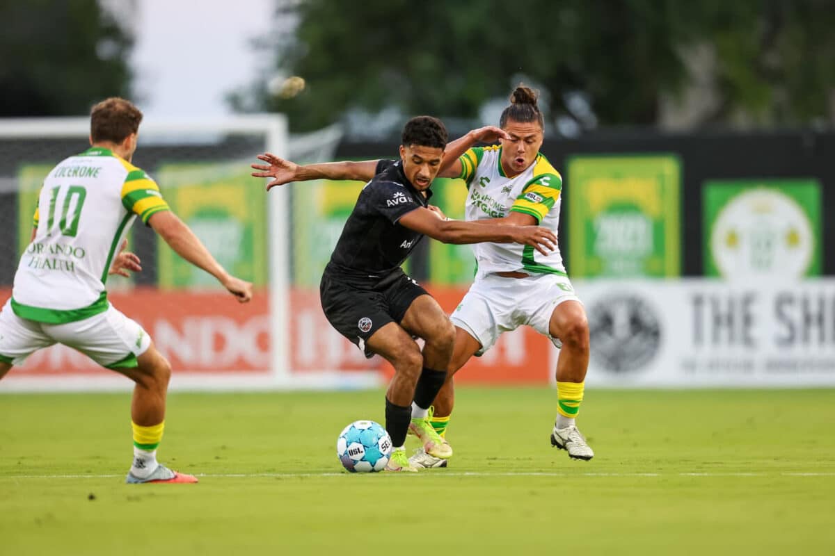 Alameda Post - Oakand Roots players dribble the ball against Tampa Bay Rowdies.