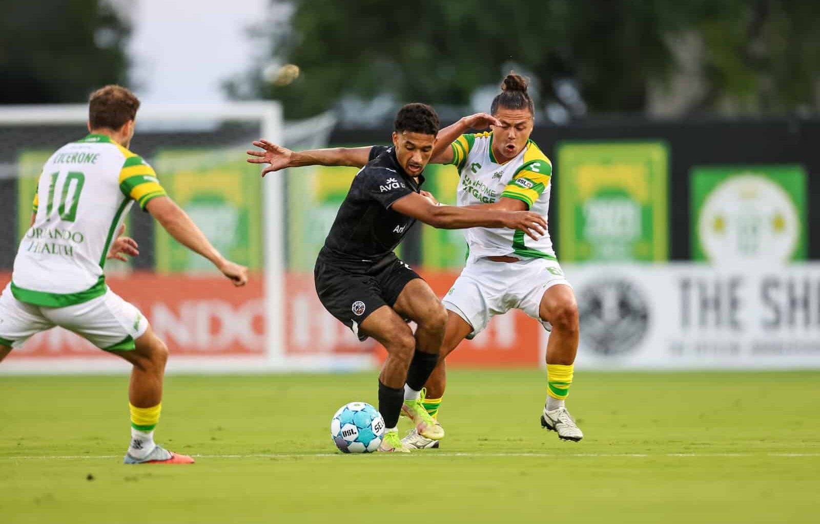 Alameda Post - Oakand Roots players dribble the ball against Tampa Bay Rowdies.