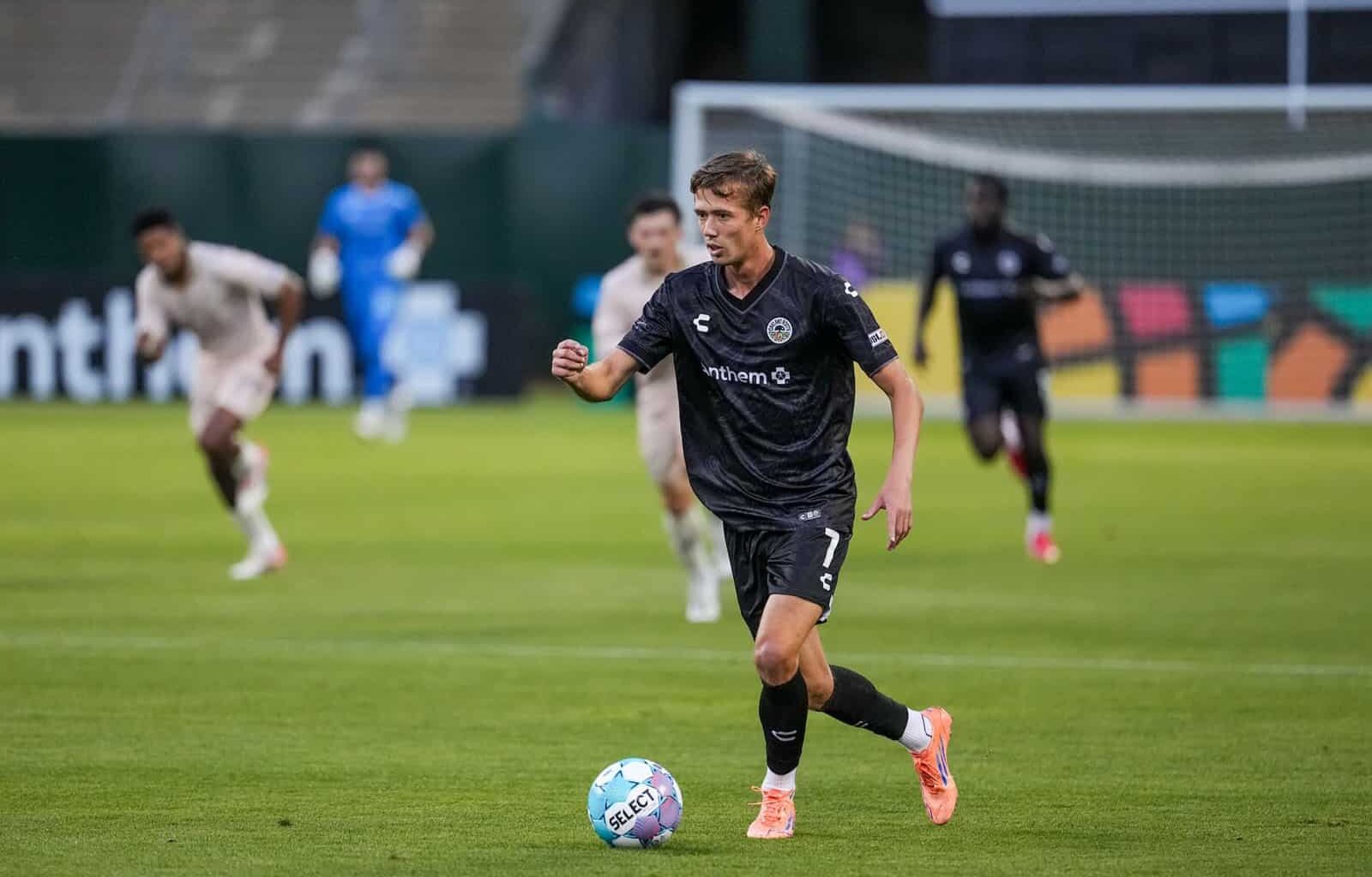 Alameda Post - An Oakland Roots player dribbles the ball in a match against FC Tulsa.