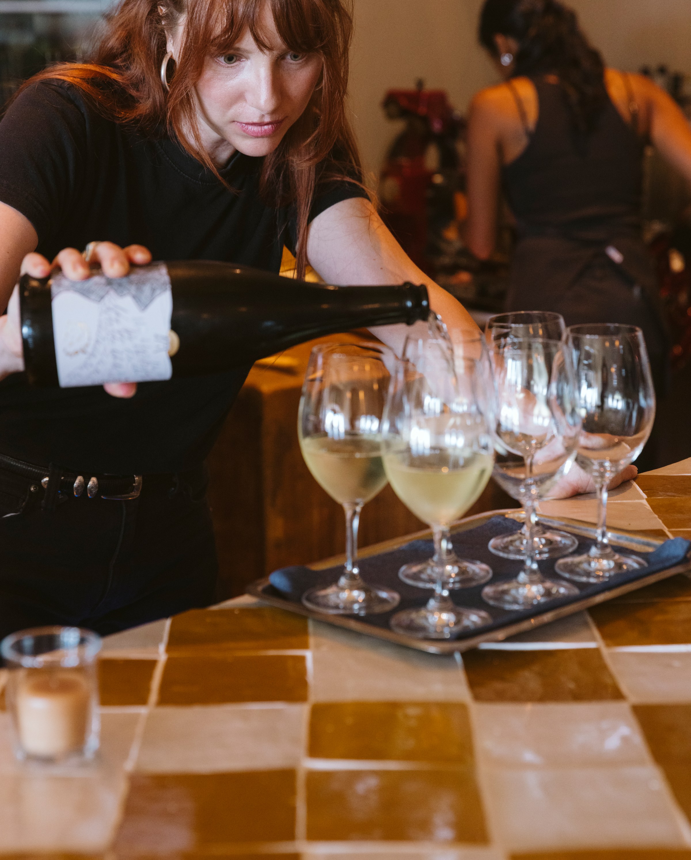 Wines being poured at a wine counter.