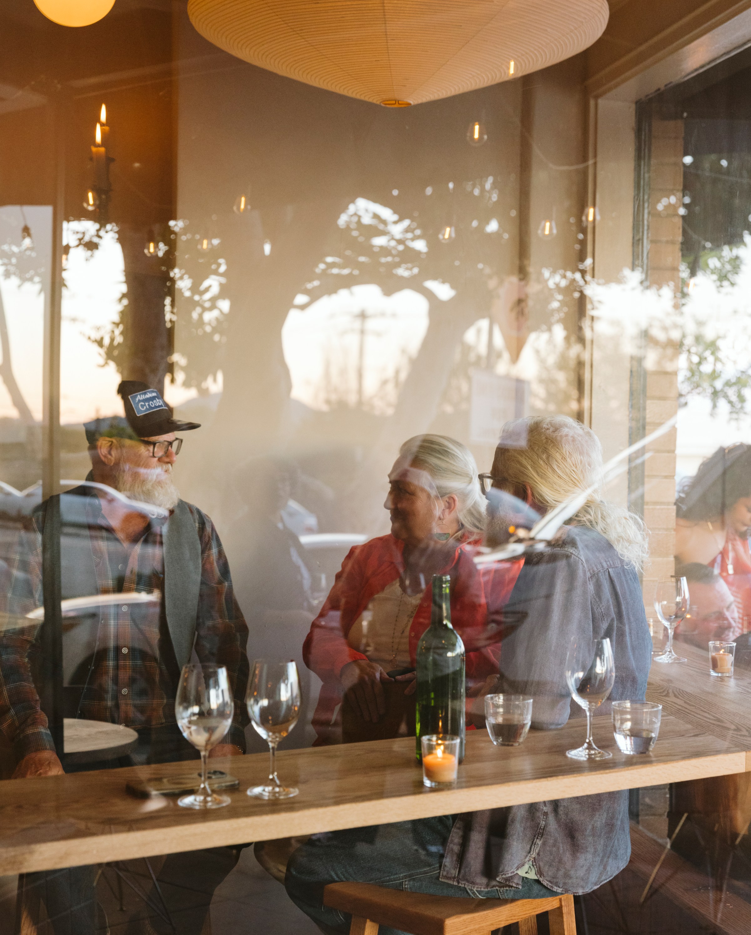 People talking through the reflection of a glass window.