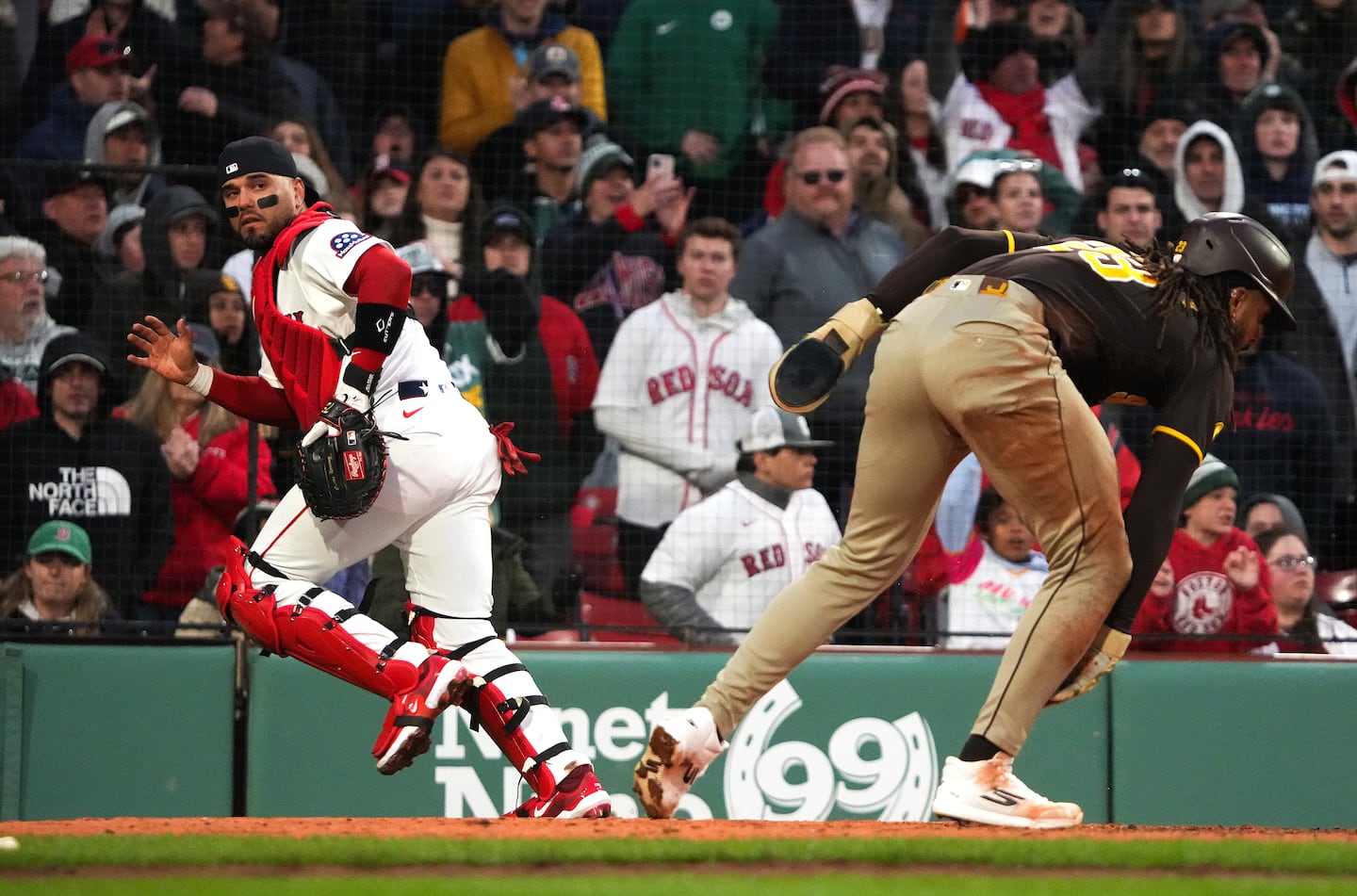 Red Sox catcher Carlos Narváez chases after the ball as Padres right fielder Fernando Tatis Jr. scores the winning run in the ninth inning.