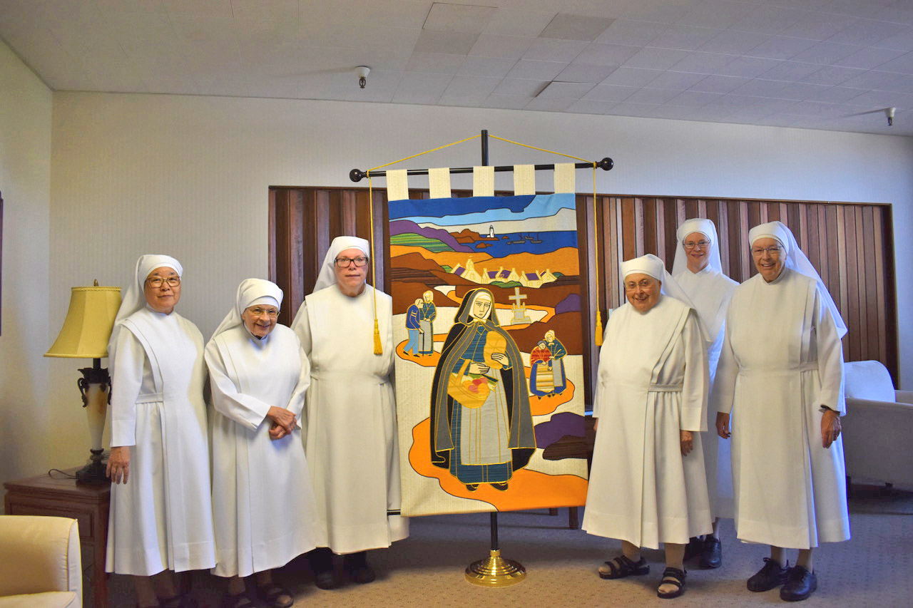 Little Sisters of the Poor with a tapestry of their...