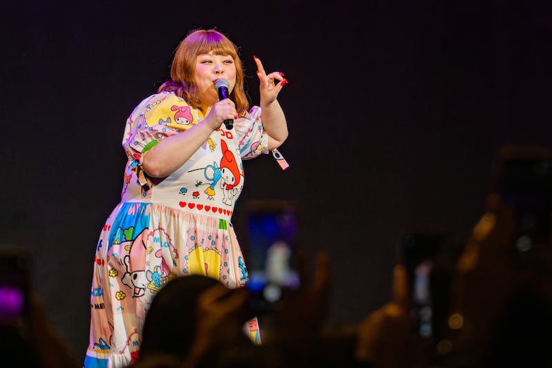 Watanabe poses a peace sign and instructs the audience that photos are allowed at the end of the show.