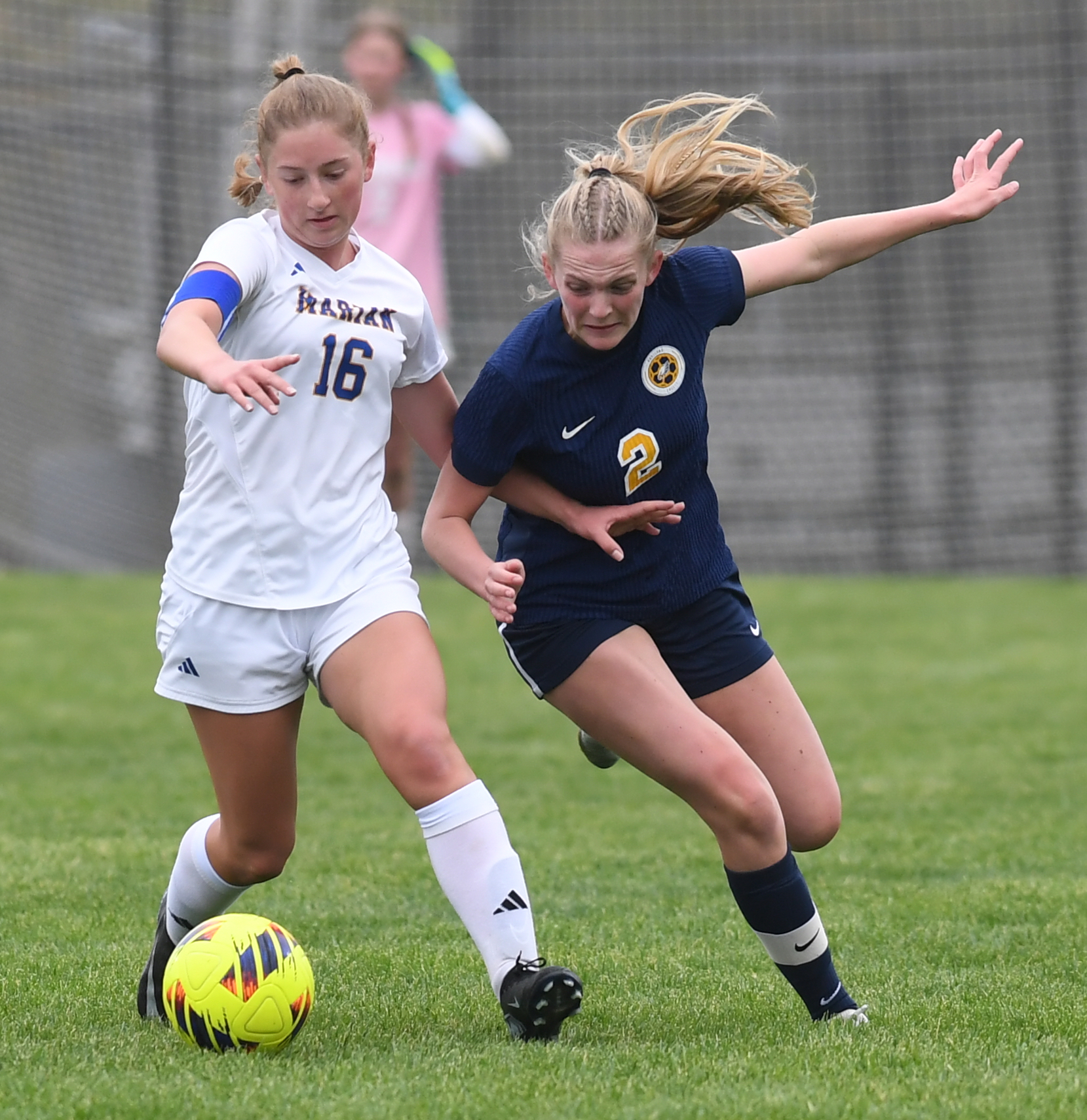Bloomfield Hills Marian's Clair Dauer (16) battles for possession with...