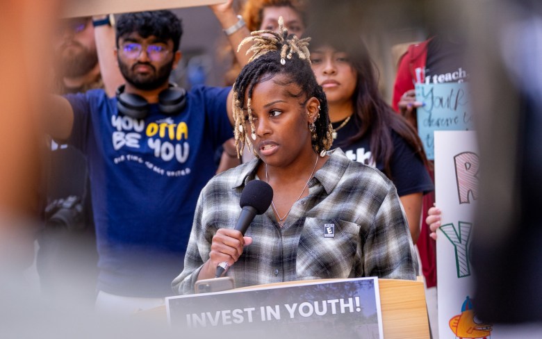 A young person speaks as part of a crowd turning out to oppose city budget cuts affecting the arts. (Photo by Thomas Murphy/Times of San Diego)