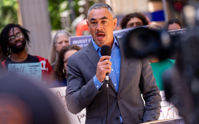 Sean Elo-Rivera speaks to a crowd outside a council meeting. A crowd of San Diegans turned out on April 20, 2026 to oppose city budget cuts affecting the arts. (Photo by Thomas Murphy/Times of San Diego)