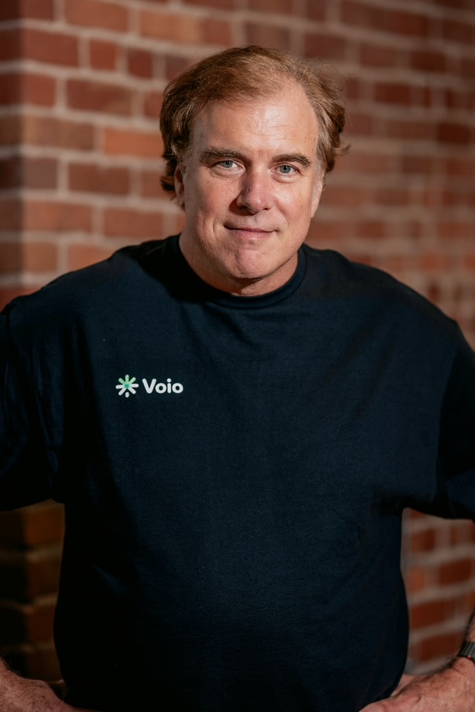 Trevor Darrell stands in front of a brick wall facing the camera. 