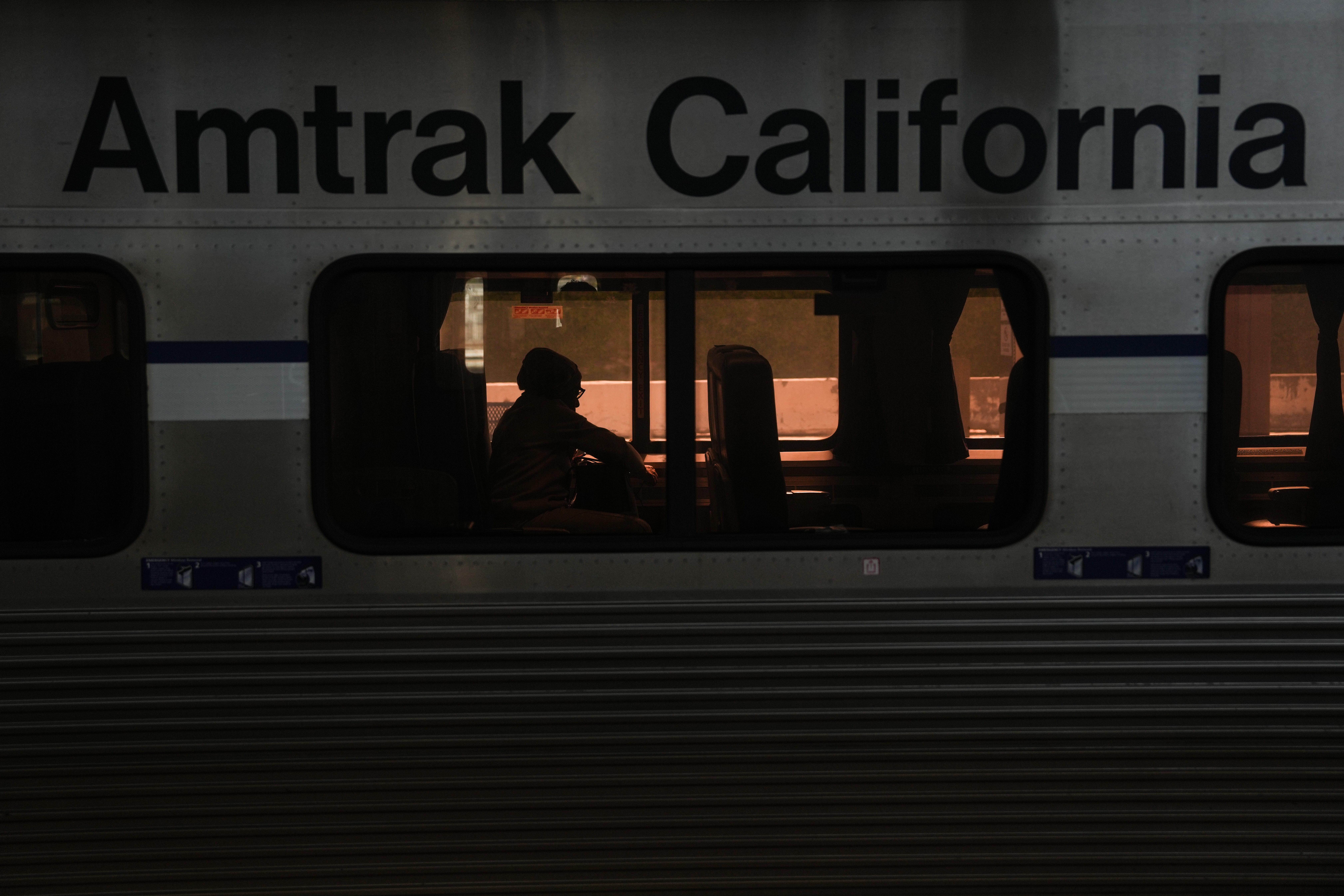 A passenger sits aboard an Amtrak train at Union Station...