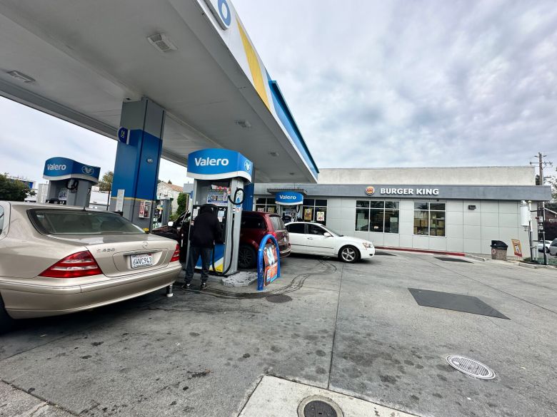 A view of a gas station, with several cars parked at the pumps