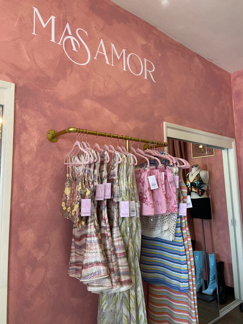 Photo of a colorful dresses on a rack.