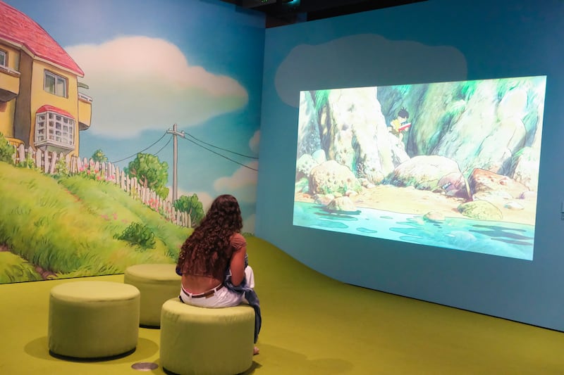 A visitor watches a looping selection of scenes from Ponyo in the playroom.