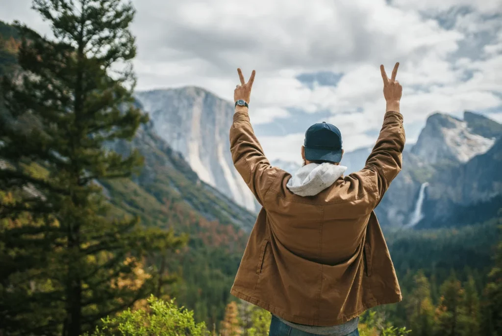 man standing in front of yosemite valley