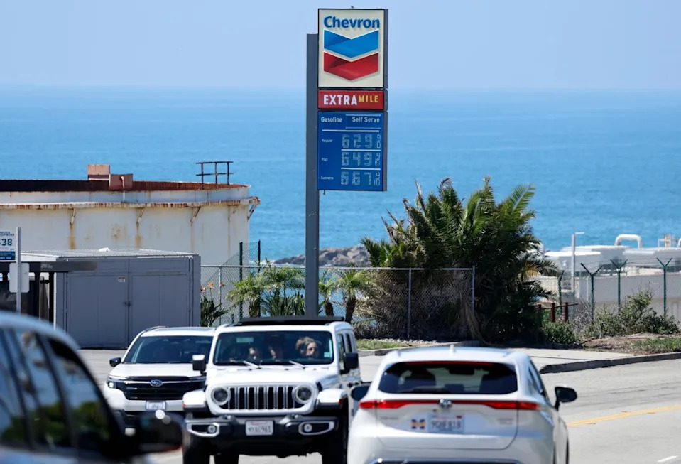A Chevron gas station sign displays high gas prices: Regular at $6.29, Plus at $6.49, and Supreme at $6.67, with the Pacific Ocean in the background. Getty Images