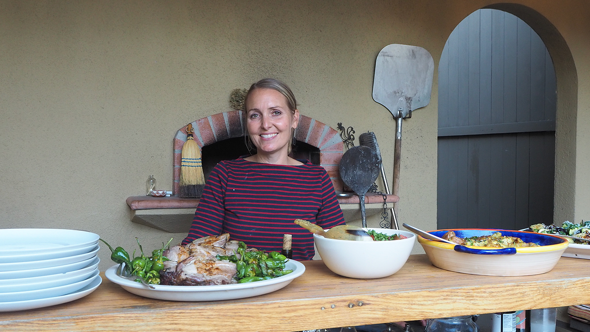 Amy Hillyard seated behind a table with prepared food