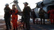 NASA astronaut Christina Koch, center left, walks across the flight deck aboard amphibious transport dock USS John P. Murtha (LPD 26) following extraction from the Orion crew module in the Pacific Ocean, April 10, 2026. John P. Murtha is underway in the U.S. 3rd Fleet area of operations supporting NASA’s Artemis II mission, retrieving the crew and spacecraft following their return to Earth and splashdown in the Pacific Ocean. NASA’s Artemis II mission sent four astronauts on a flight around the moon in
