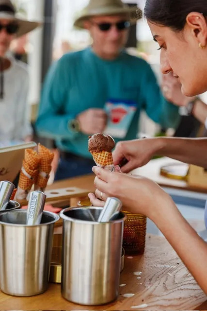 A person scooping a small ice cream cone