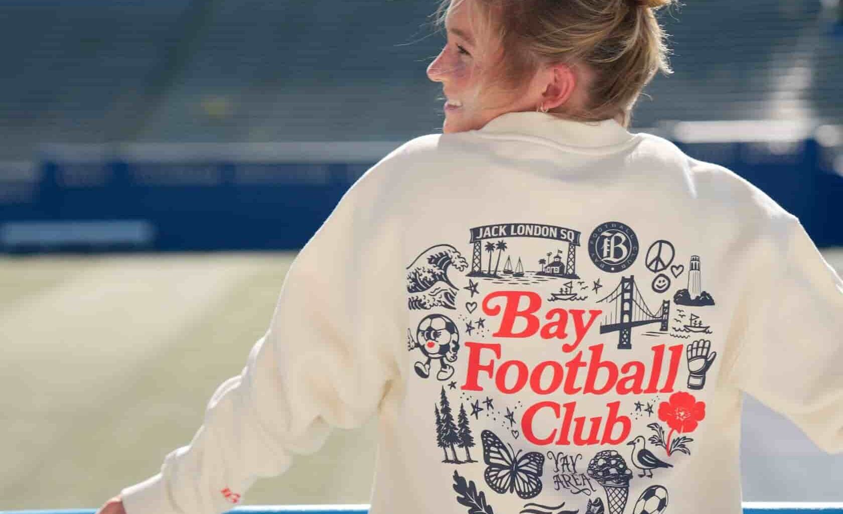 Bay FC player modeling Bay FC x Oaklandish sweatshirt at NWSL PayPal Park in San Jose.