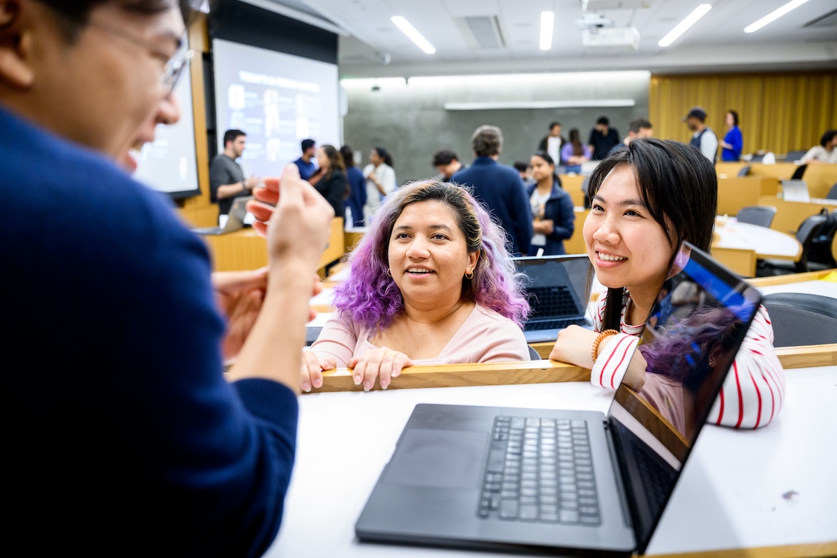 two students looking at a laptop