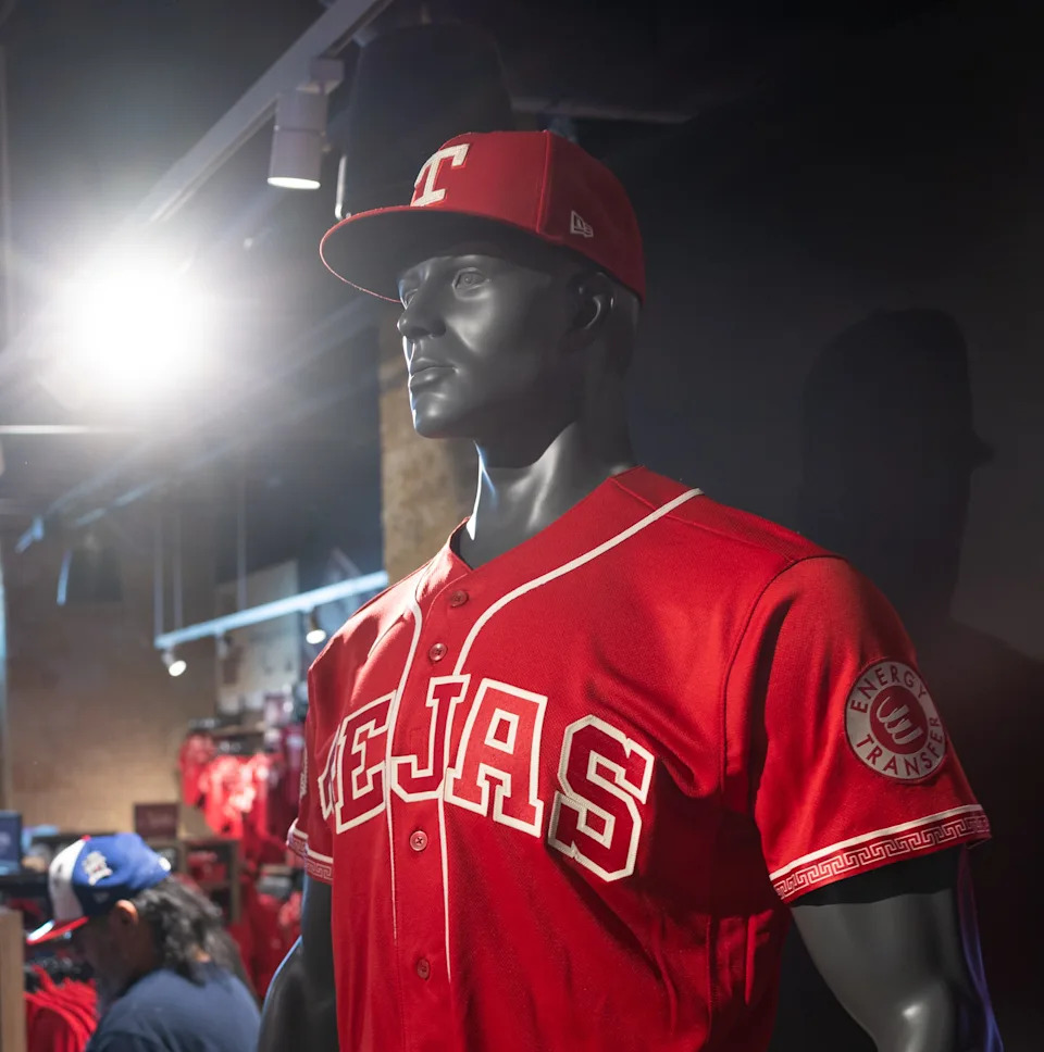 ARLINGTON, TEXAS - APRIL 9: Chelby Coley of <a class="link " href="https://sports.yahoo.com/mlb/teams/atlanta/" data-i13n="sec:content-canvas;subsec:anchor_text;elm:context_link" data-ylk="slk:Atlanta;sec:content-canvas;subsec:anchor_text;elm:context_link;itc:0" data-yga="{"yLinkElement":"context_link","yModuleName":"content-canvas","yLinkText":"Atlanta","ySubModuleName":"anchor_text","yHasCommerce":false}">Atlanta</a> takes a photo of the new <a class="link " href="https://sports.yahoo.com/mlb/teams/texas/" data-i13n="sec:content-canvas;subsec:anchor_text;elm:context_link" data-ylk="slk:Texas Rangers;sec:content-canvas;subsec:anchor_text;elm:context_link;itc:0" data-yga="{"yLinkElement":"context_link","yModuleName":"content-canvas","yLinkText":"Texas Rangers","ySubModuleName":"anchor_text","yHasCommerce":false}">Texas Rangers</a> City Connect jersey at Globe Life Field's Grand Slam Team Store in Arlington, TX, Thursday, April 9, 2026. (Juan Figueroa/The Dallas Morning News via Getty Images)