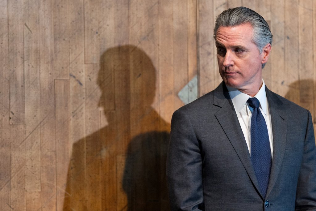 California Governor Gavin Newsom, dressed in a suit and tie, at the inauguration of installations at San Quentin Rehabilitation Center.